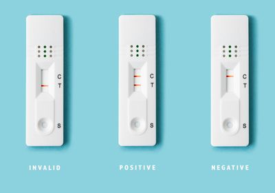 Three covid rapid antigen tests displaying (left to right) invalid, positive, and negative results.