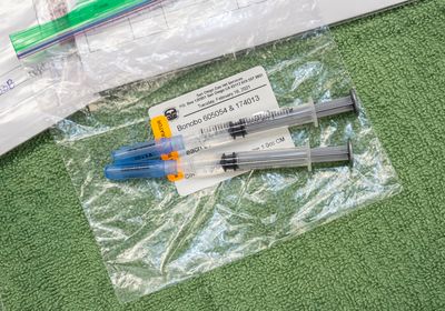 Two vaccine syringes on a baggy labelled with San Diego Zoo and Bonobo