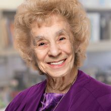 Ursula Bellugi smiling for the camera wearing a purple shirt in 2015