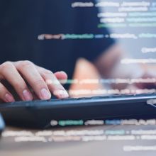 close up programmer student man hand typing on keyboard at computer desktop to input code language into software for study bug and defect of system in classroom , development of technology concept