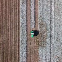 An aerial view of a harvester in a cotton field