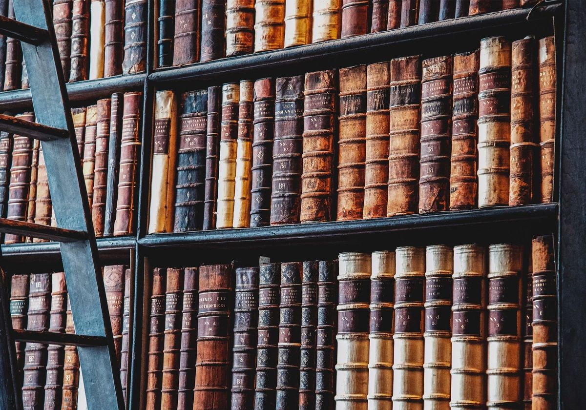 A bookshelf in a library filled with old books.