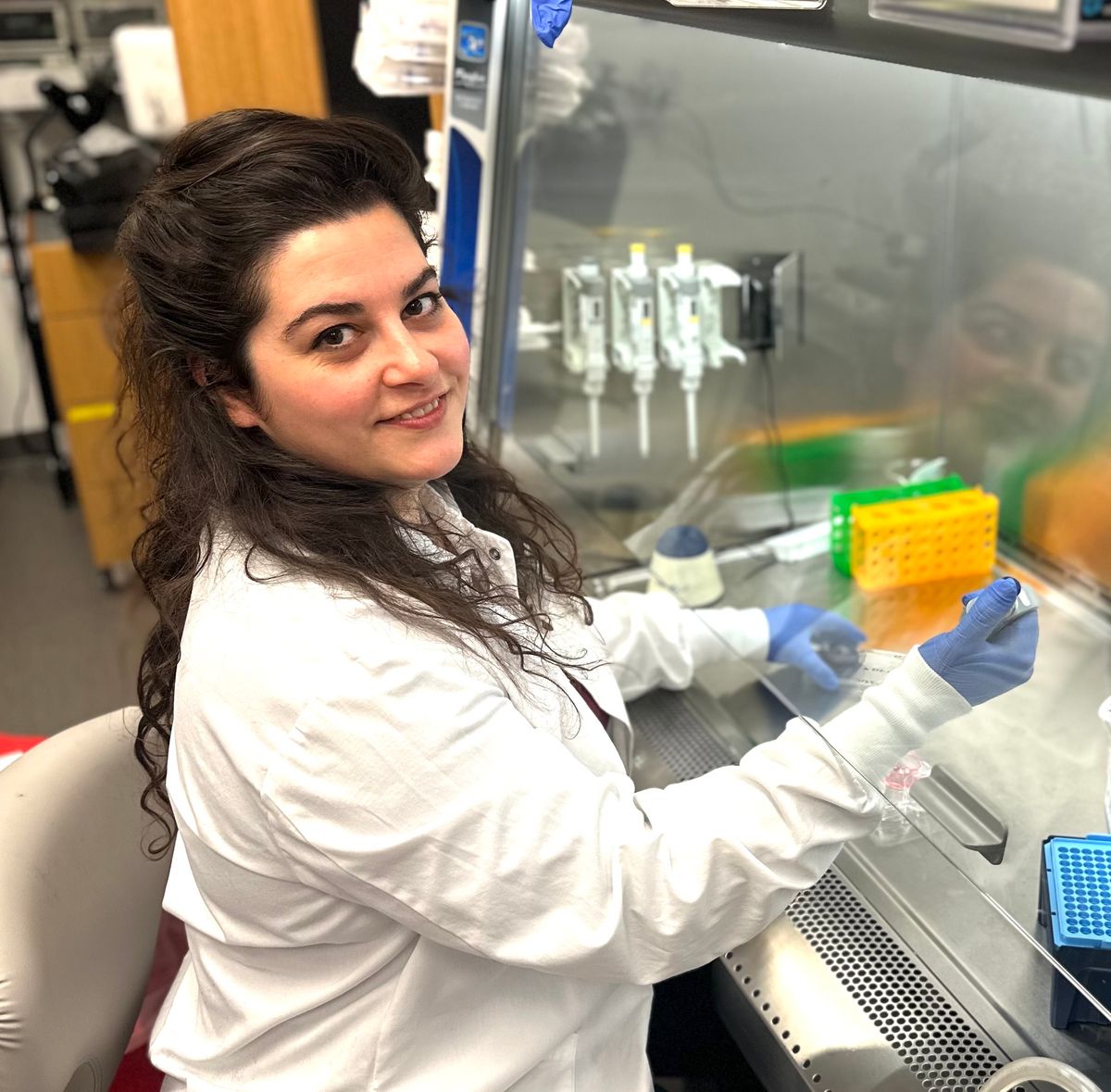 Image of Gizem Gumuskaya working under a laboratory fume hood.