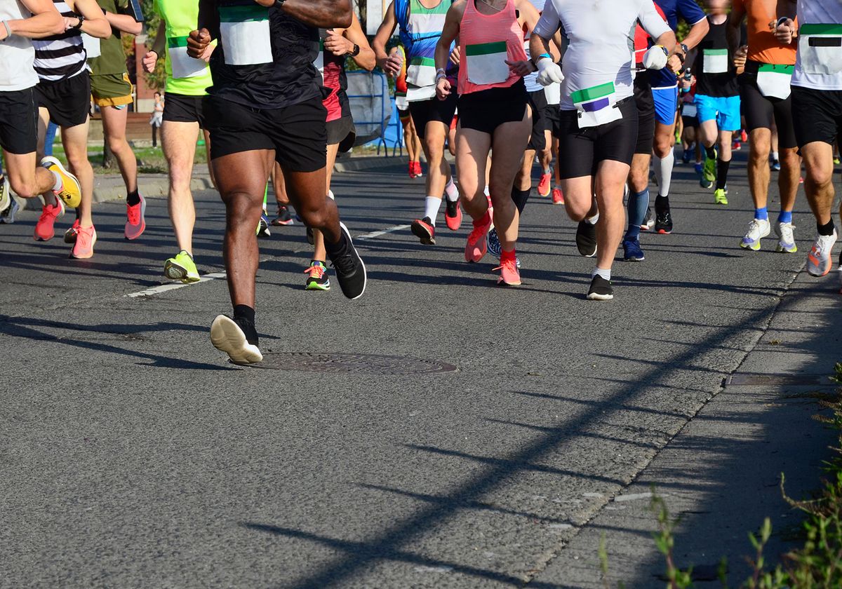 Image showing the legs of multiple people running in the street. 