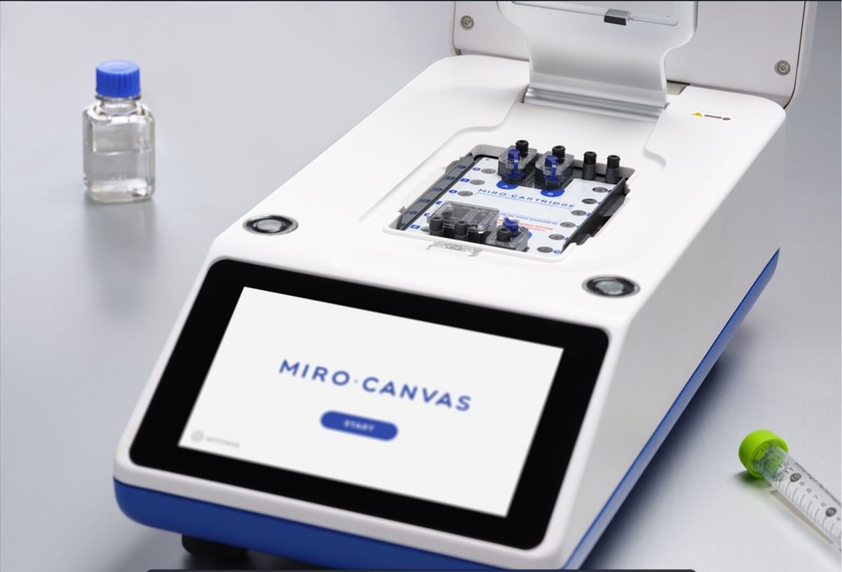 Image of a laboratory next generation sequencing automated instrument in white, blue, and black, on a lab bench background.