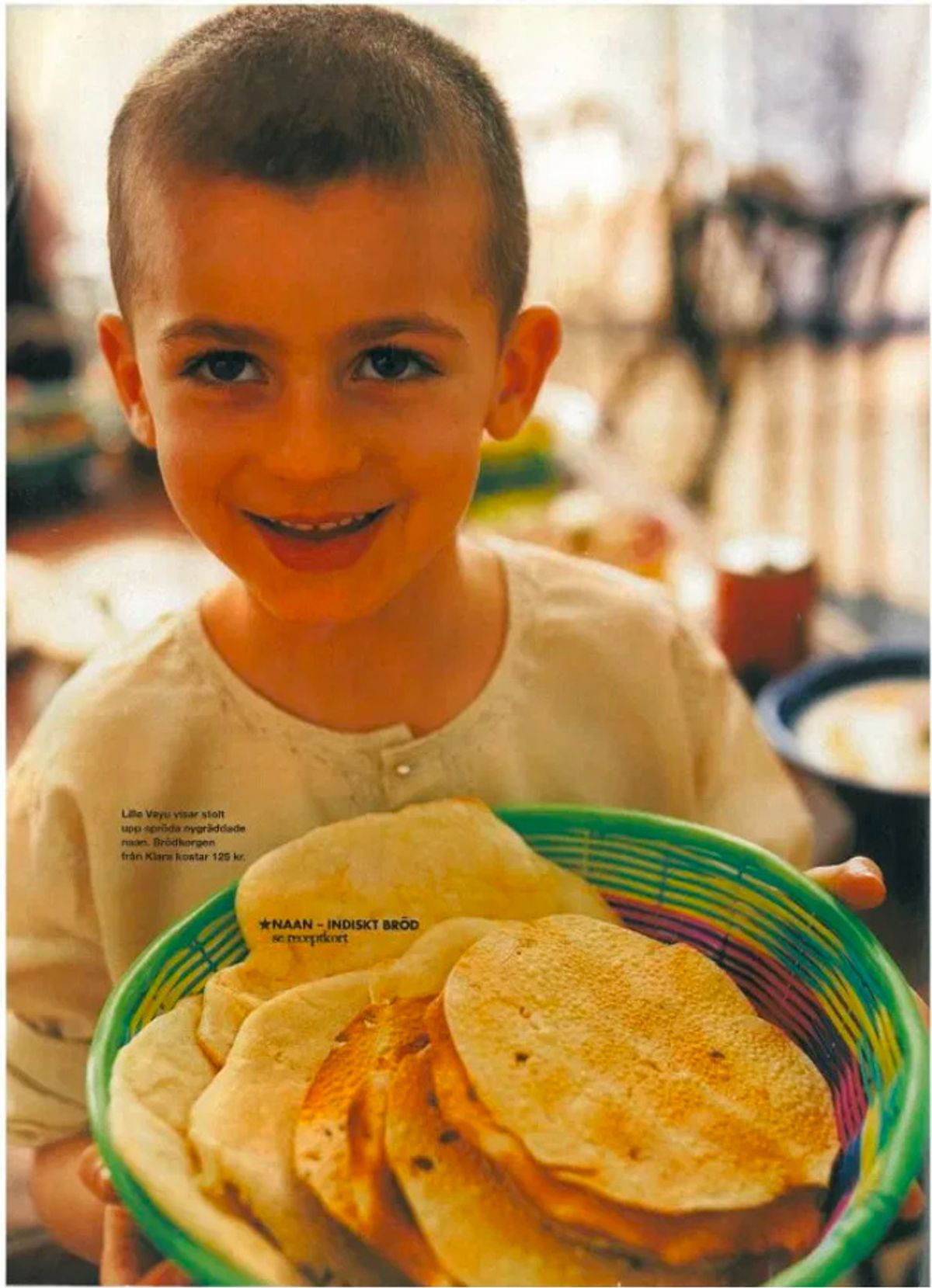 Photograph of a young Vayu Hill-Maini holding a basket of flatbreads.