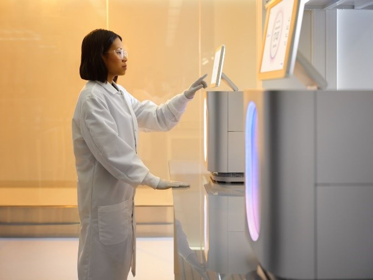 Photo of a scientist touching the screen of Illumina’s MiSeq i100 sequencer