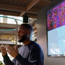 An individual standing in front of a screen, delivering a lesson.