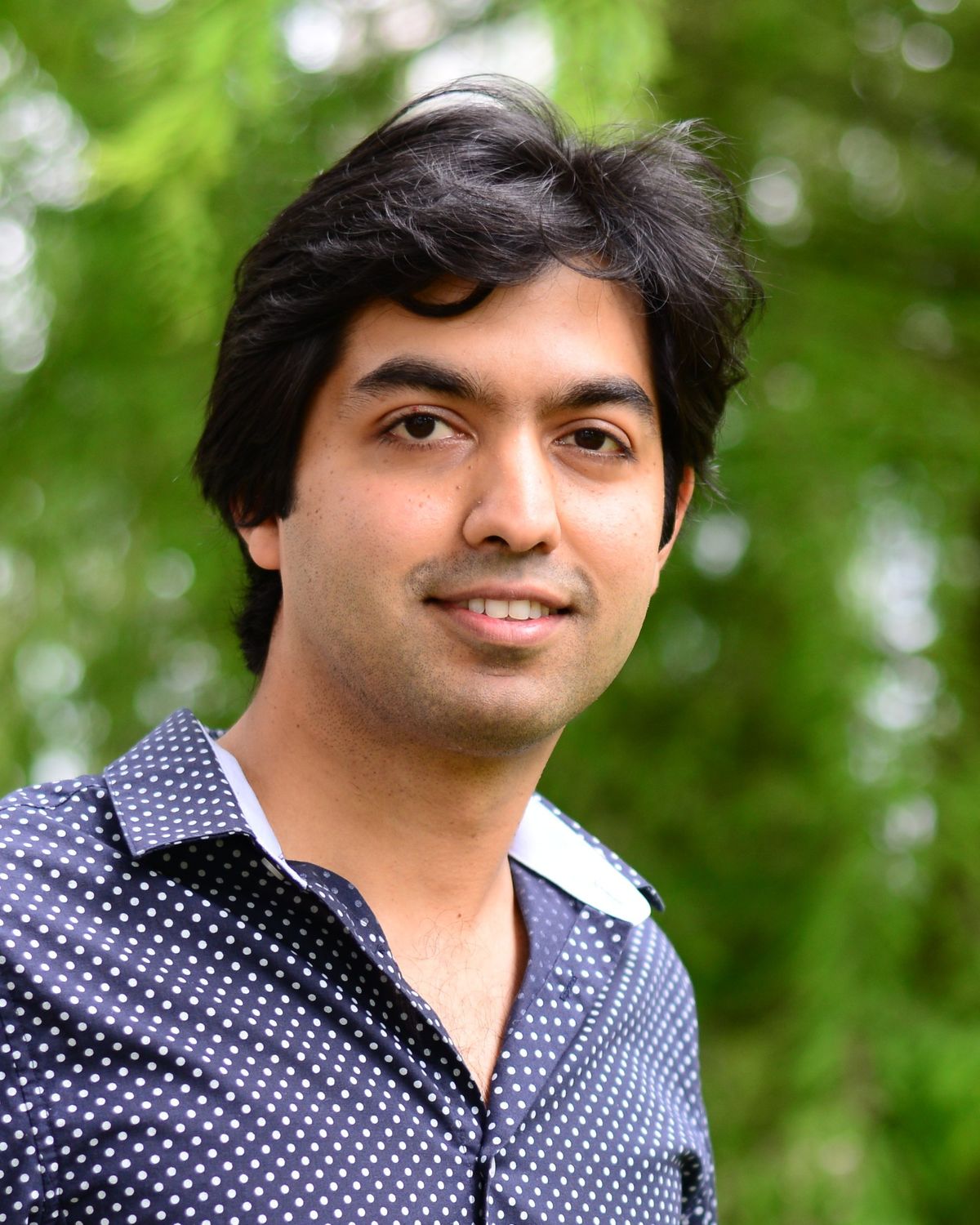 A picture of the biophysicist Siddharth Deshpande against a green backdrop.