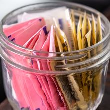 A jar full of artificial sweetener packets.